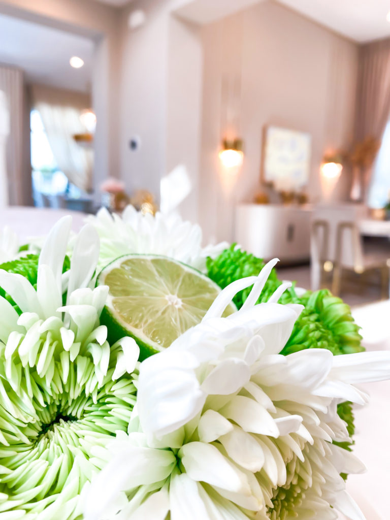 A WHITE AND GREEN FLORAL ARRANGEMENT WITH LIME AND CARNATIONS