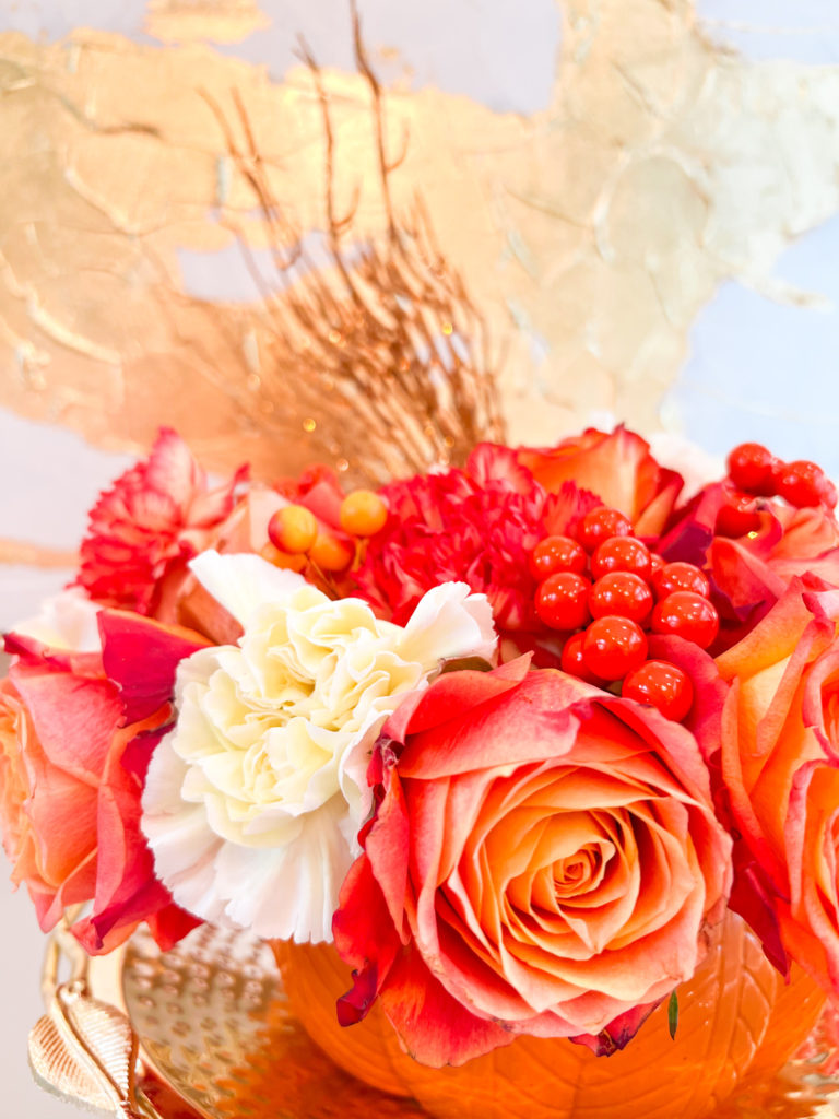fall flowers in a pumpkin vase
